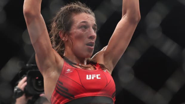 Jun 12, 2022; Singapore, SIN; Joanna Jedrzejczyk (blue gloves) reacts after the fight against Zhang Weili (red gloves) during UFC 275 at Singapore Indoor Stadium. Mandatory Credit: Paul Miller-USA TODAY Sports